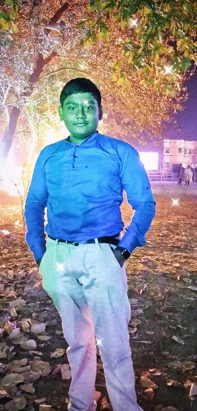 Man in blue shirt stands in nighttime urban setting with glowing lights and leaves.