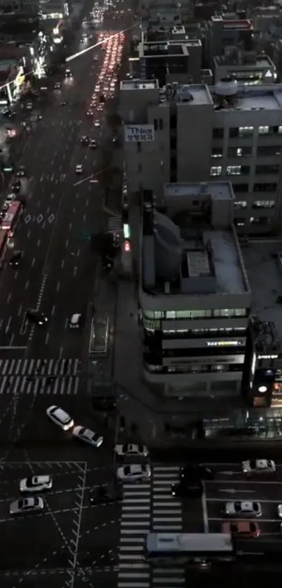 High-angle view of a city street at night with illuminated buildings and traffic.