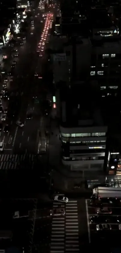 Aerial night view of a busy city street with glowing lights.