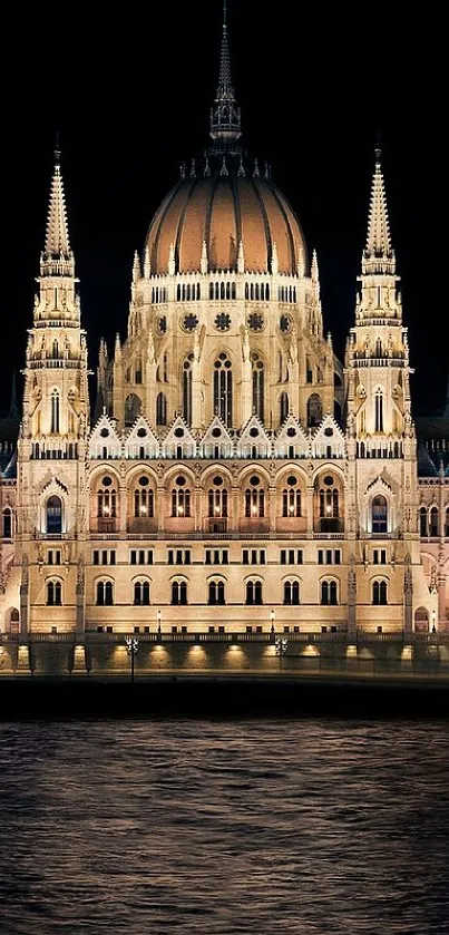 Illuminated parliament building at night with water reflection.