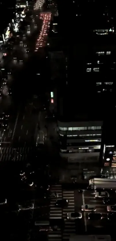 A vibrant city street at night with glowing car headlights and dark buildings.