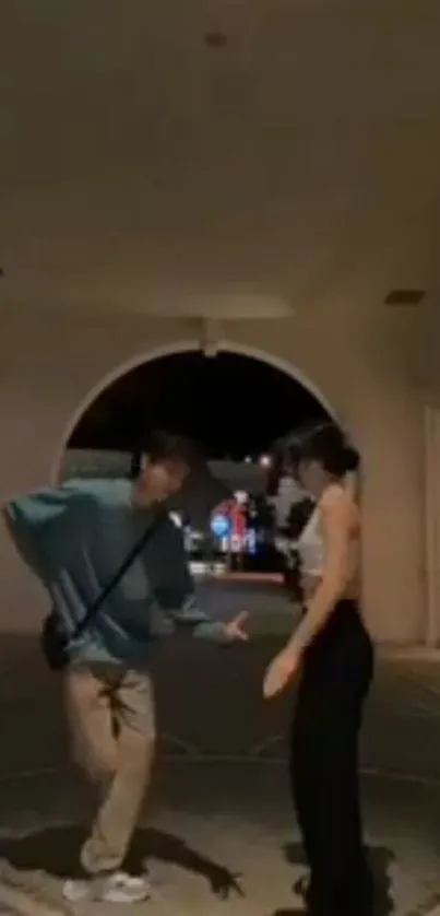 Two people dancing in an urban night scene.