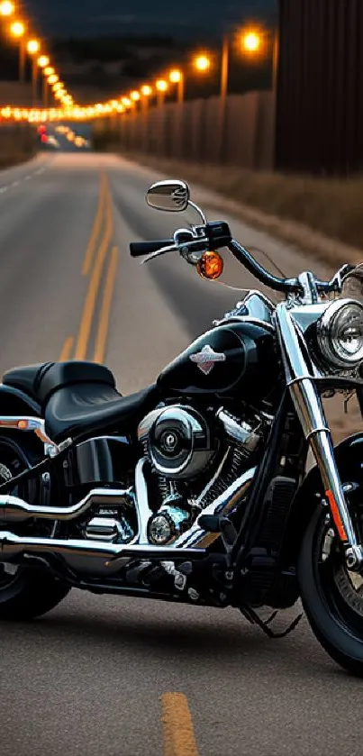 Motorcycle on night road with bright street lights and distant mountains.