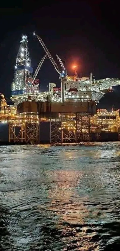 Illuminated offshore oil rig at night over dark ocean.