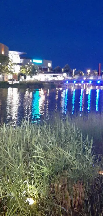 Nighttime river reflection with urban lights and blue sky.