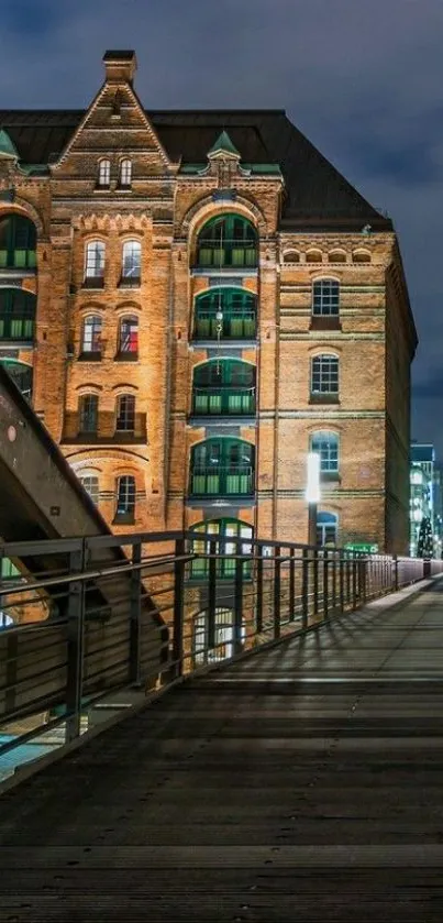 Night-time view of a brick building with pathway and city lights.