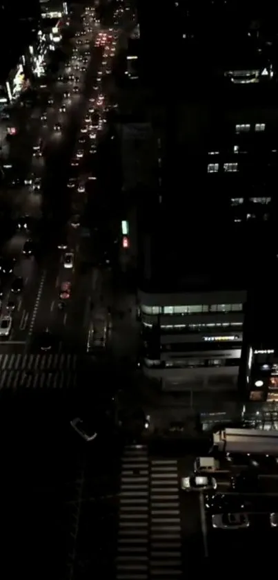 A nighttime aerial view of an illuminated city street with bustling traffic.