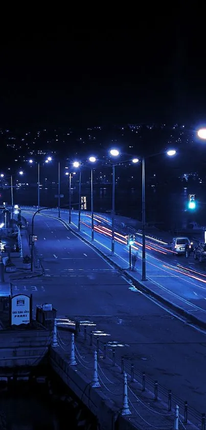 Blue-lit urban street at night with streetlights glowing.