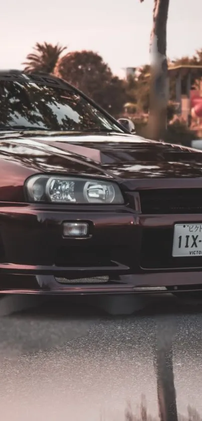 Maroon Nissan Skyline R34 in urban setting.