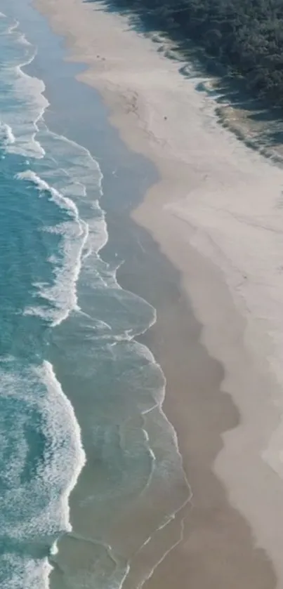 Aerial view of ocean waves meeting the sandy beach.