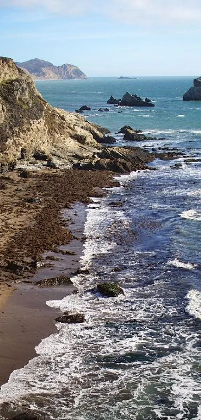 Mobile wallpaper of ocean waves hitting a rocky cliffside under a clear sky.