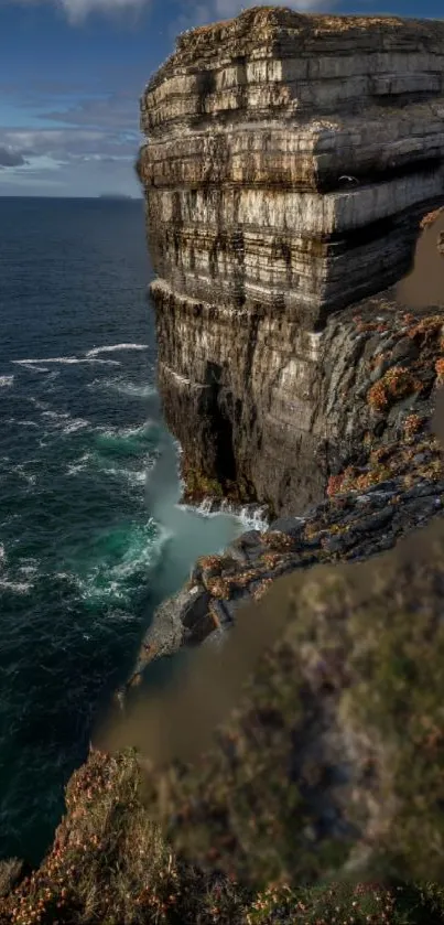 Stunning view of a cliff overlooking the vast ocean with crashing waves below.