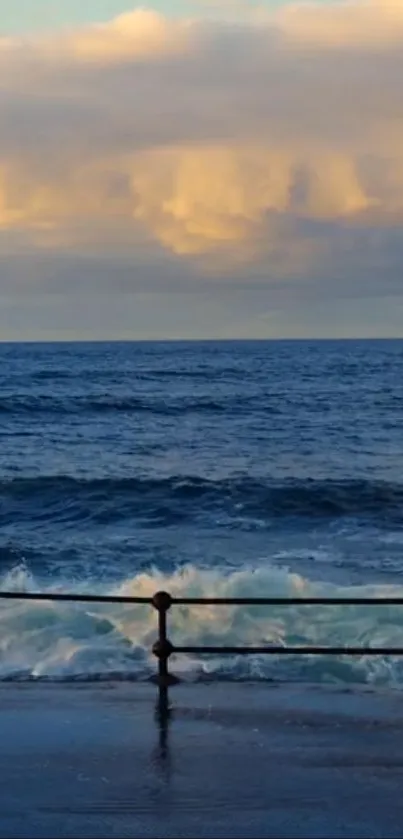 Ocean waves crash against the shore at sunset with a golden sky.