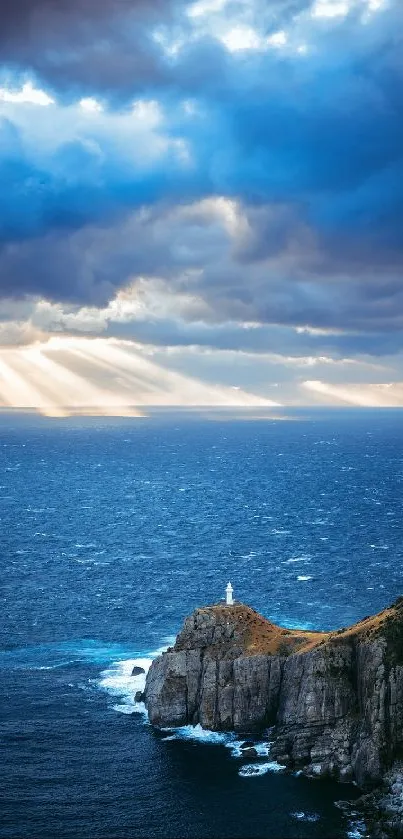 Dramatic sky over ocean with lighthouse on a cliff.