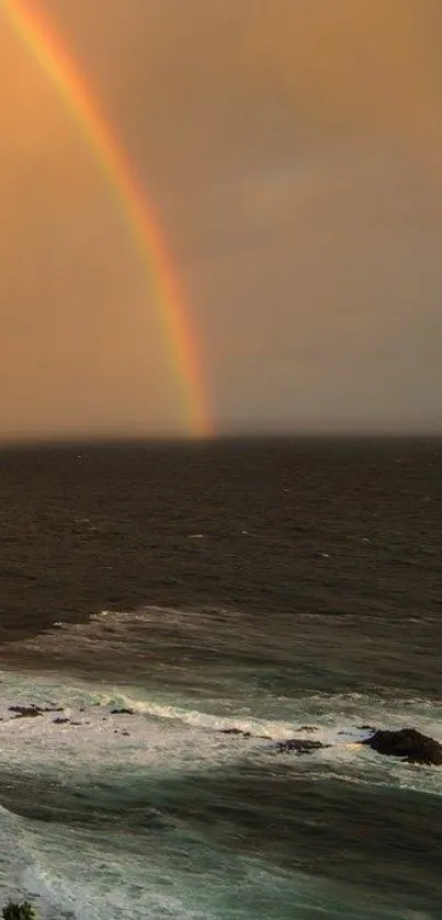 Vibrant rainbow stretching over a tranquil ocean at sunset.