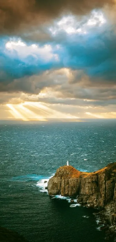 Dramatic sunset over ocean with lighthouse perched on cliff.