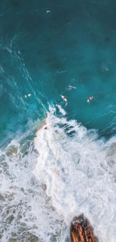 Aerial view of surfers riding turquoise ocean waves.