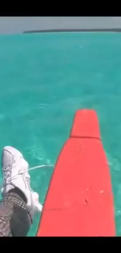 Turquoise ocean with a red canoe and a distant horizon.