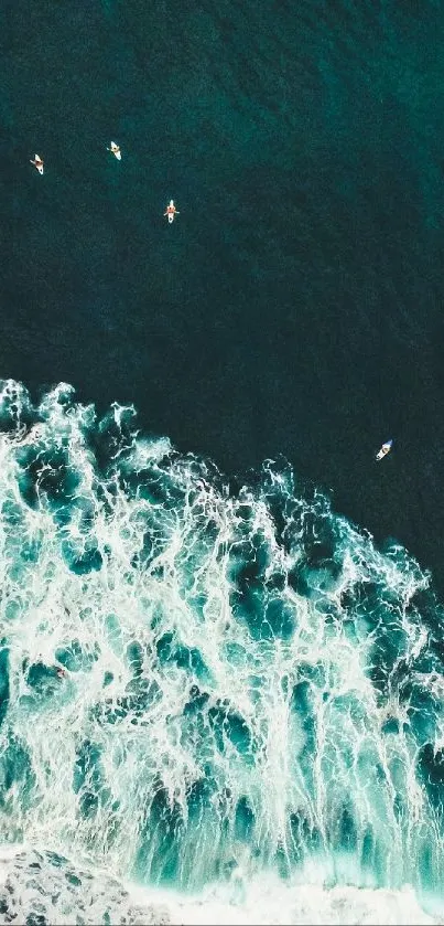 Aerial view of ocean waves with surfers, capturing dynamic teal and white tones.