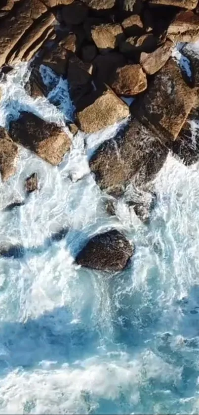 Aerial view of ocean waves crashing against rocky coastline wallpaper.