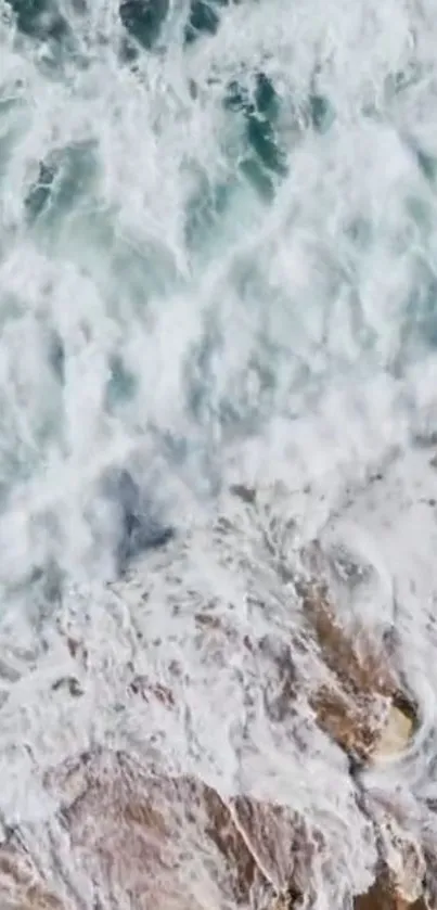 Aerial view of ocean waves crashing against rocky shore creating white foam.