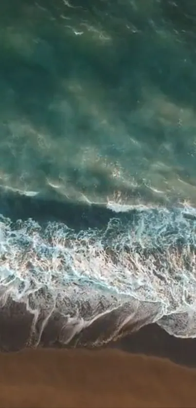 Aerial view of ocean waves crashing on a sandy shore, in vibrant turquoise hues.