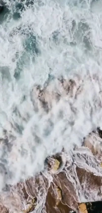 Aerial view of ocean waves crashing over rocks.