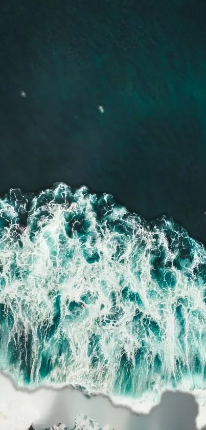 Aerial view of crashing ocean waves with teal blue waters.