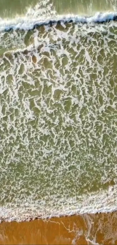 Aerial view of ocean waves and sandy shore in soothing seafoam green.