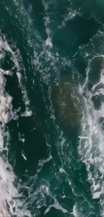 Aerial view of teal ocean waves with foamy white crests.