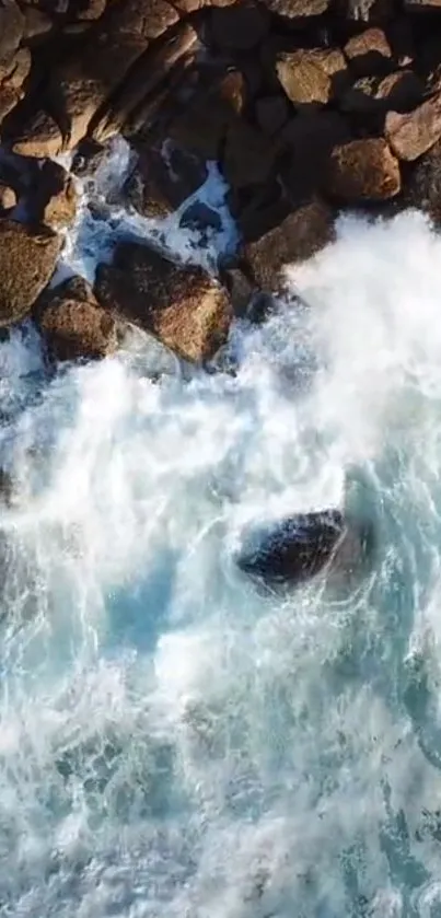 Aerial view of ocean waves crashing against rugged coastal rocks.