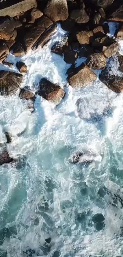 Top view of ocean waves crashing against rocks.