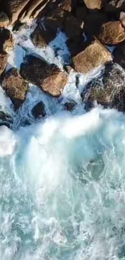 Aerial view of waves crashing against rocky shores with white and blue ocean spray.