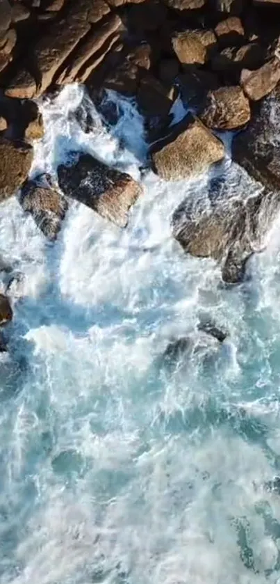 Aerial view of ocean waves crashing onto rocky shore.