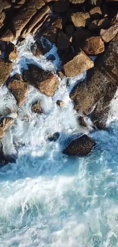 Aerial view of ocean waves crashing against rugged coastal rocks.