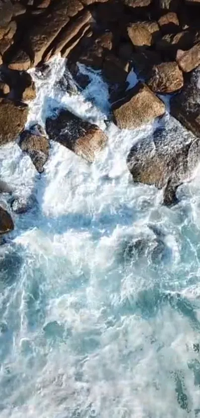 Aerial view of ocean waves crashing against rocky shore.