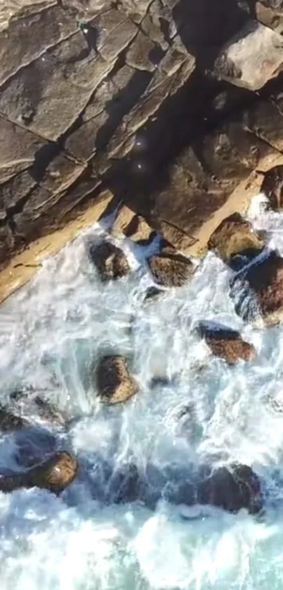 Aerial view of ocean waves crashing on rocky cliffs.