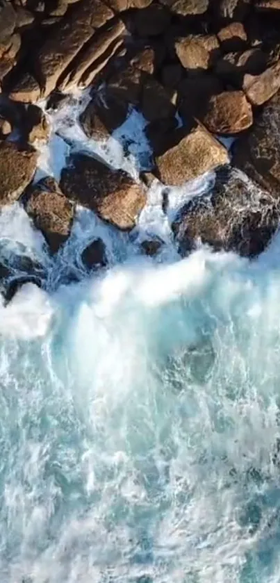 Aerial view of waves crashing on rocky shore, vibrant blue ocean.