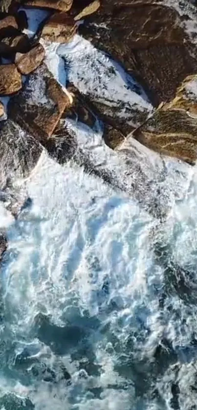 Aerial view of ocean waves crashing onto rocky coastline, showcasing water splashes.