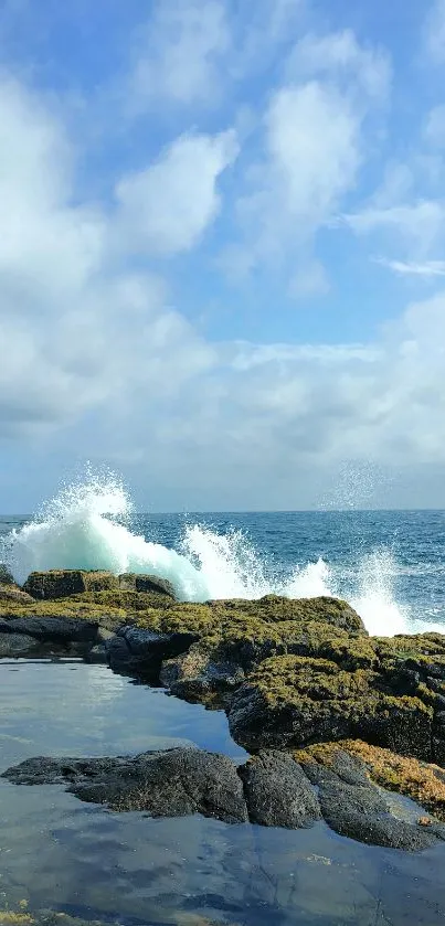 Ocean waves crash against a rocky shore under a blue cloudy sky.