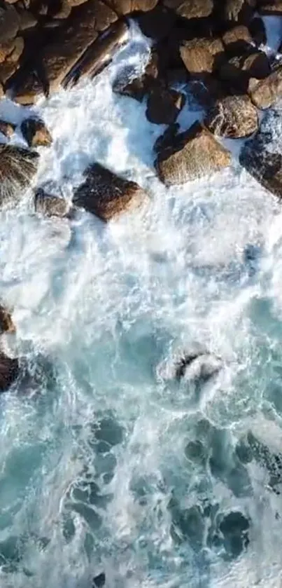 Aerial view of ocean waves crashing against rocky shore.