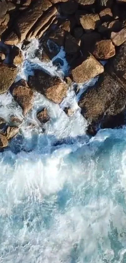 Aerial view of blue ocean waves crashing on rocky shoreline.