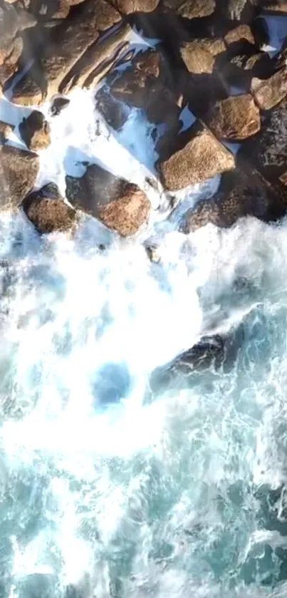 Aerial view of ocean waves crashing onto a rocky shore with dynamic water movement.