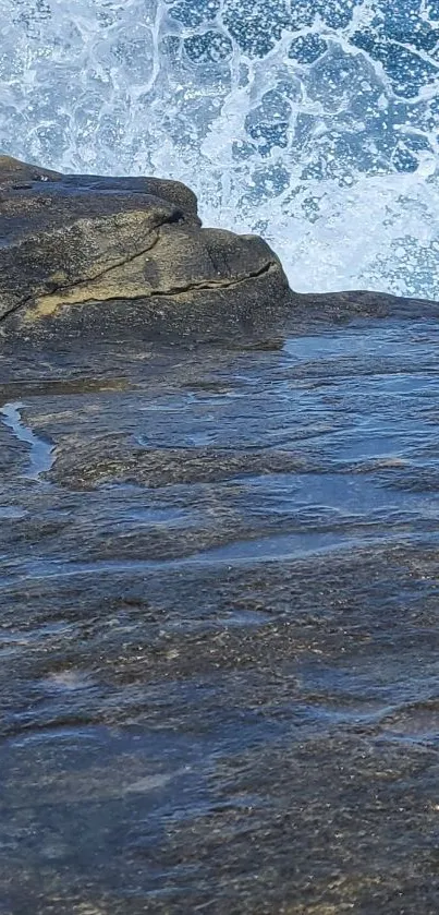 Ocean waves crashing on rocky shore on mobile wallpaper.