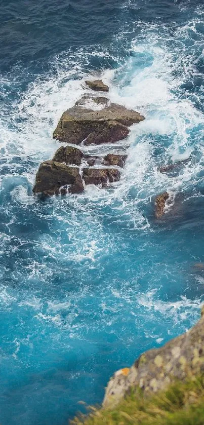 Blue ocean waves crashing on rocky shore in a scenic mobile wallpaper.