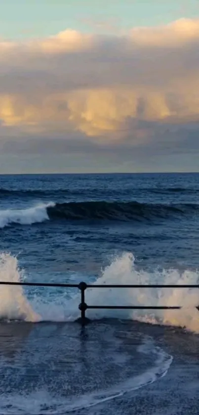 Ocean waves crashing against a railing at sunset.