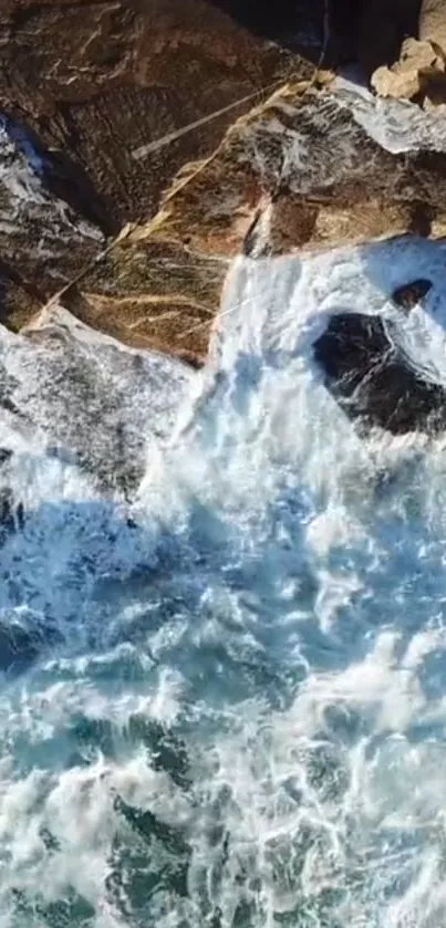 Aerial view of ocean waves crashing onto rocky shore.