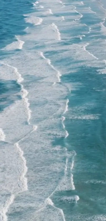 Ocean waves with serene blue hues crashing along a sandy coast.