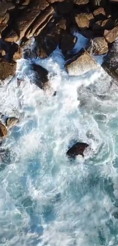 Blue ocean waves crashing over brown rocks on a sunny day.