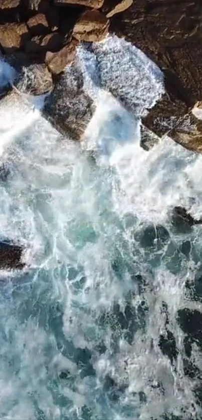 Waves crashing on rocky shore, captured from above.